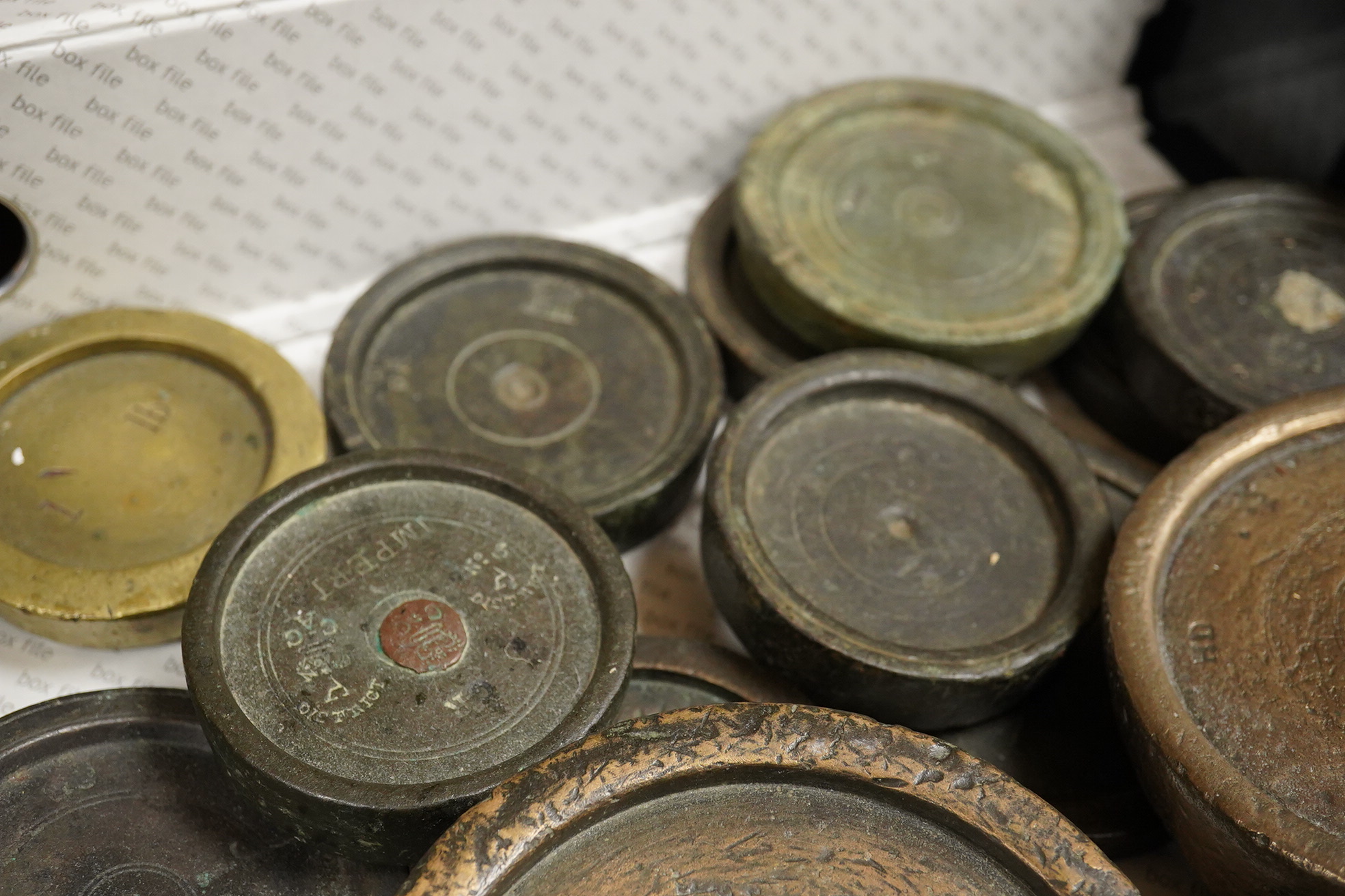 A collection of mainly 18th and 19th century bronze imperial circular trade weights and bell weights, stamped with Royal Cyphers, weights, the dagger assay mark for London, other proof marks, etc., contained within two b